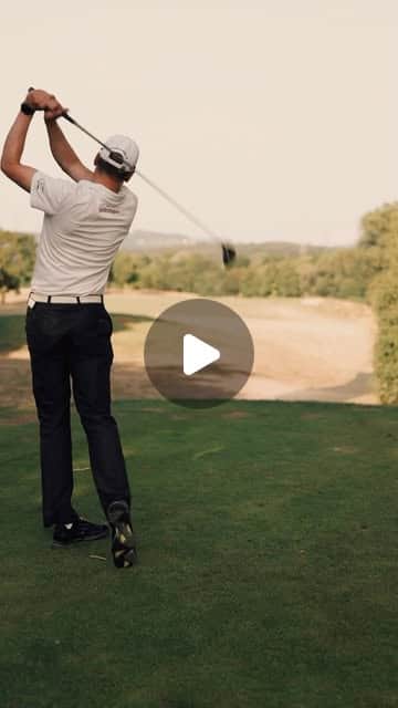 Golfer beim Abschlag auf dem Fairway, Schwung von hinten festgehalten in warmem Abendlicht