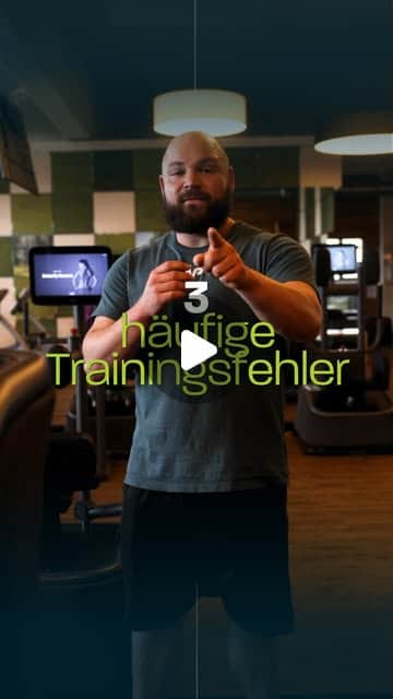 Bärtiger Fitnesstrainer im Studio zeigt in die Kamera, Text-Overlay zu häufigen Trainingsfehlern