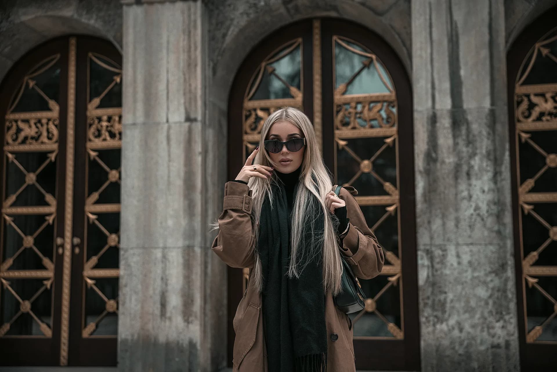 Fashion Foto einer Frau mit blonden Haaren und braunem Mantel und Sonnenbrille, posiert vor einer luxuriösen Location in Stuttgart, Fotografier von Nicolas Bär