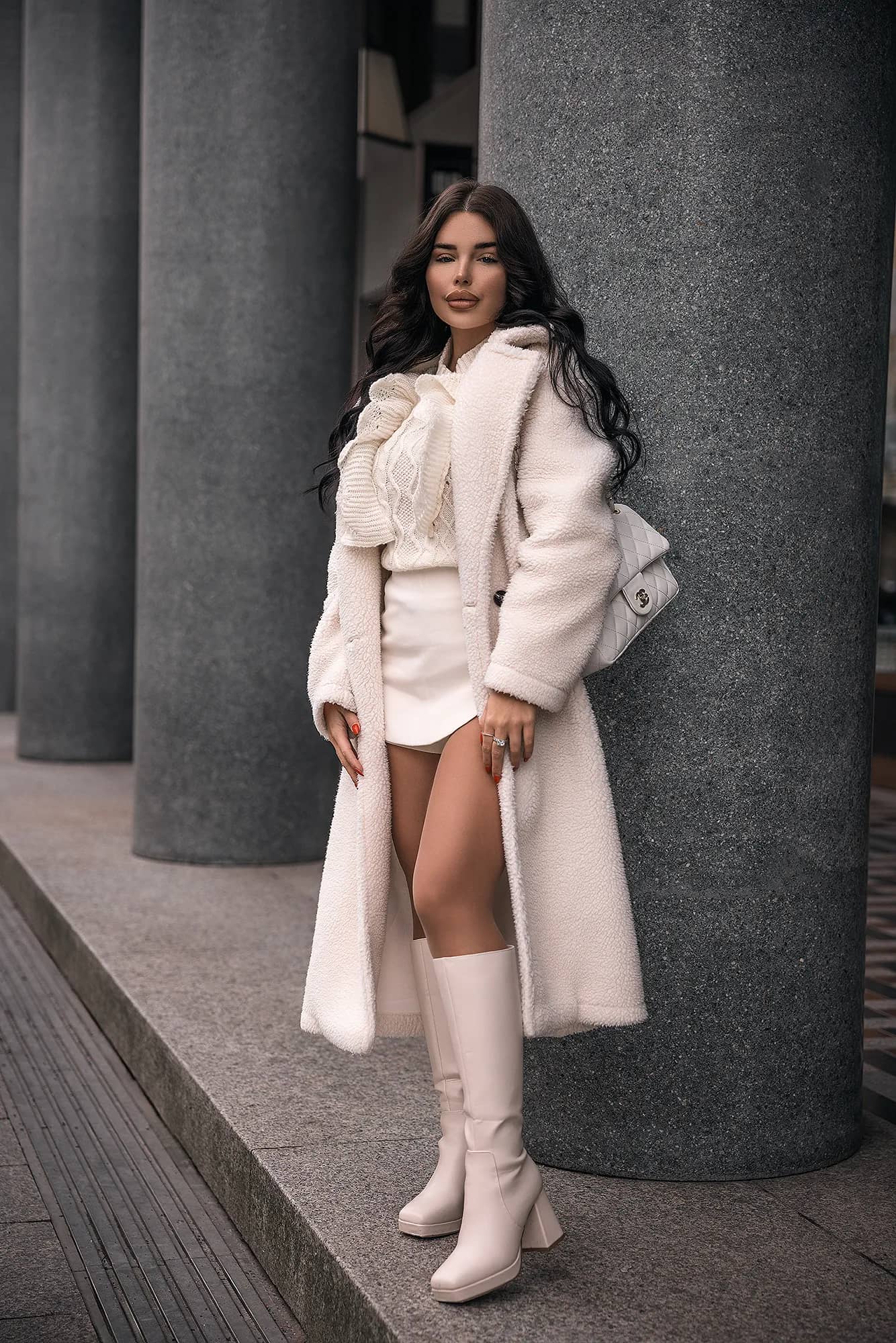 Fashion-Bild einer Frau in einem eleganten weißen Mantel und Stiefeln, fotografiert von Nicolas Bär